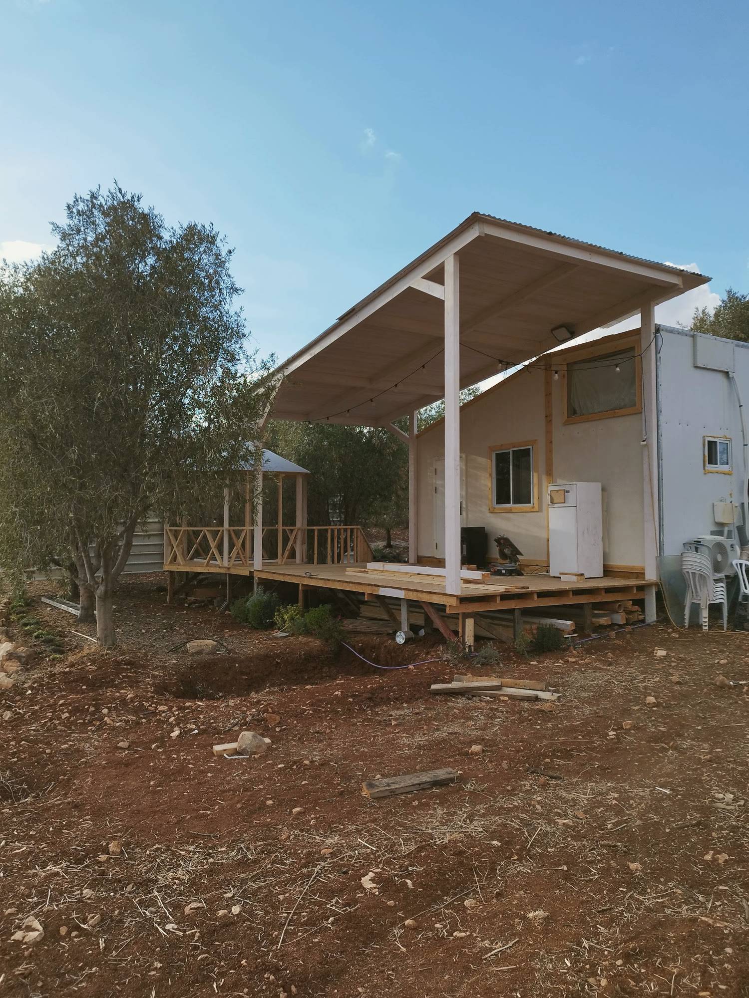 הבית במקומו, עם דק עץ וגג מעליו